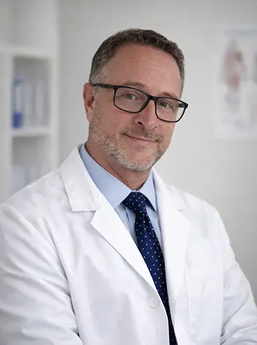 Matt Wurst smiling in a white coat and tie.
